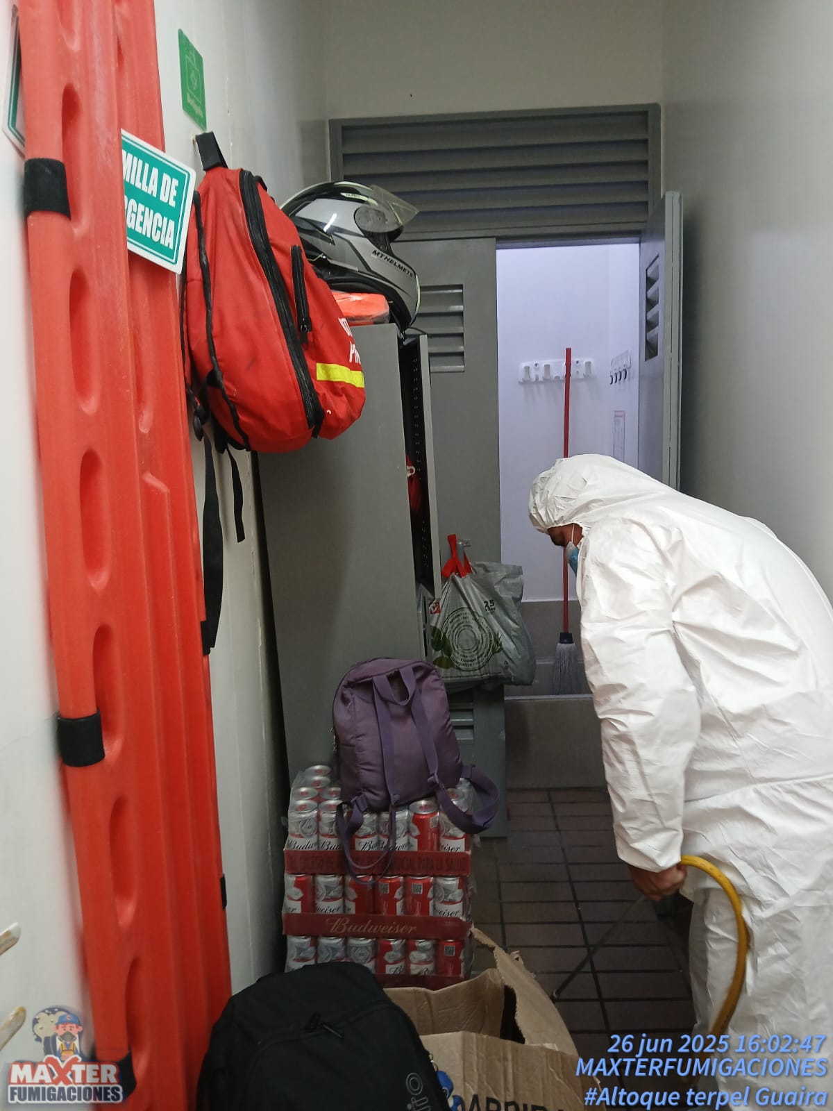 Técnico de Maxter con traje de protección fumigando un cuarto de servicio